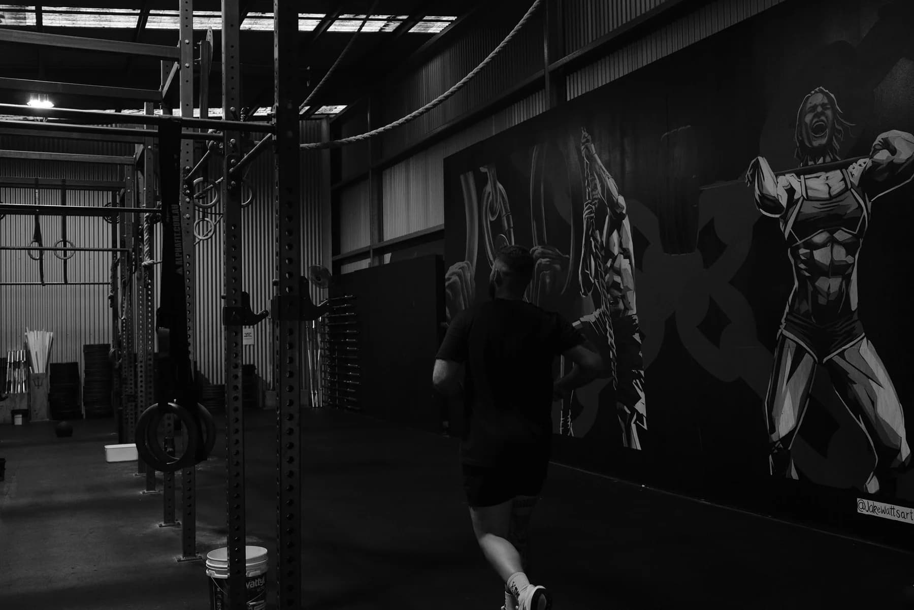 A member training beside the WITHIN gym mural during a Functional Fitness session
